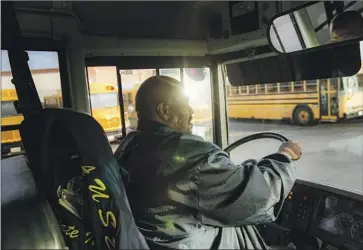  ?? SCHOOL BUS Gina Ferazzi Los Angeles Times ?? driver John Lewis, 56, pulls into the Gardena bus yard Friday afternoon. Lewis, who makes $34 an hour, has driven for the district for three decades. His day starts at 5:30 a.m. and ends at 5:30 p.m.