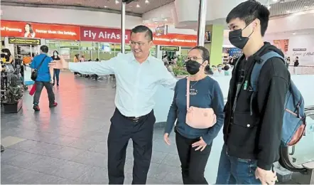  ?? ?? Free at last: (From right) Koh with his mother Loke and Ch’ng walking through the Penang internatio­nal airport in bayan Lepas, Penang.