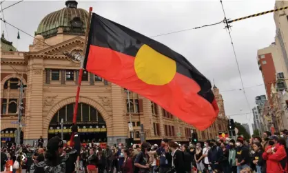 ?? Photograph: Anadolu Agency/Getty Images ?? Indigenous Australian­s protest on 26 January in Melbourne. ‘We march the streets and fly our flags because we love our children.’