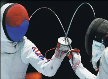  ?? BEAWIHARTA / REUTERS ?? Jeon Hee-sook (left) of South Korea duels with Sera Azuma of Japan during the Asian Games women’s individual foil semifinal in Jakarta on Monday. Jeon won and went on to defeat China’s Fu Yiting 8-3 in the final.