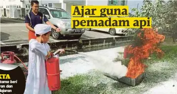  ??  ?? SEORANG pelajar tahfiz memadamkan api seperti yang diajar pihak bomba.