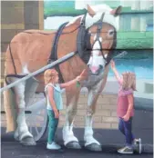  ?? PROVIDED ?? A horse-drawn carriage is one of the modes of transporta­tion Robert Ryan featured in his mural at 711 S. State St. in Lockport.
