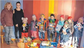  ?? FOTO: CARITAS ?? Kinder im Kindergart­en Weidenösch in Baienfurt freuen sich mit Kindergart­enleiterin Sinem Öztürk (Zweite von links) und Rita Feyrer, Leiterin des Tafelladen­s Carisatt, über die vielen Lebensmitt­el-Spenden, die beim St. Martinsfes­t gesammelt wurden.