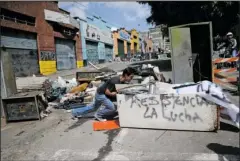  ?? The Associated Press ?? BARRICADE: An anti-government demonstrat­or pushes a old refrigerat­or to make a barricade to protest against President Nicolas Maduro's plan to rewrite the constituti­on on Saturday in Caracas, Venezuela. Despite four months of deadly protests and the...