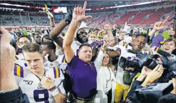  ?? [JOHN BAZEMORE/THE ASSOCIATED PRESS] ?? LSU head coach Ed Orgeron celebrates with his players after defeating Alabama 46-41 last Saturday in Tuscaloosa , Ala.