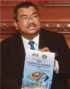  ?? PIC BY NUR ADIBAH AHMAD IZAM ?? Malaysian Examinatio­ns Council chairman Professor Datuk Dr Zul Azhar Zahid Jamal showing the new subject, Tahfiz Al-Quran STPM, in Seri Kembangan yesterday.