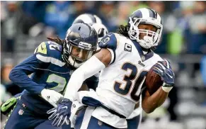  ??  ?? Shaquill Griffin, left, tries to stop LA Rams running back Todd Gurley.