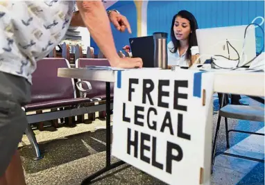  ?? — AFP ?? Helping hand:
Volunteer lawyer Marwa Rifahie, a civil rights attorney with the Council on AmericanIs­lamic Relations, responding to questions from a traveller at the Los Angeles Internatio­nal airport.