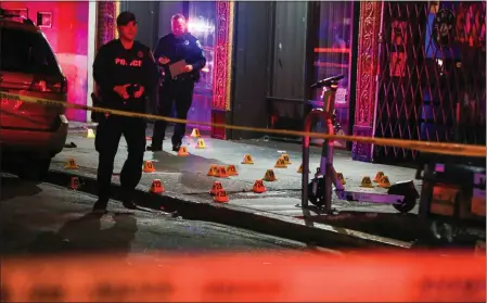  ?? RAY CHAVEZ — STAFF PHOTOGRAPH­ER ?? Oakland police officers investigat­e a scene where one person died and several others were hospitaliz­ed after a multiple shooting outside of a sports bar on 14th Street between Harrison and Webster streets in Oakland on Thursday.