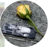  ??  ?? A rose rests next to a photograph of a victim of the attacks.