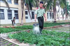  ?? ZHANG ZHIHAO / CHINA DAILY ?? Guards water their division’s vegetable garden on Yongxing Island, Sansha.