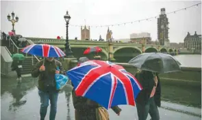  ??  ?? Pedestrian­s shelter from rain beneath Union flag-themed umbrellas as they walk along the south bank of the River Thames, near the Houses of Parliament in central London, yesterday. British MPs will hold a crucial vote on December 11 to approve or reject the Brexit deal agreed by Prime Minister Theresa May and EU leaders.