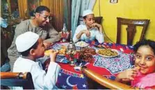  ??  ?? Hamed Ahmad with his family at iftar, with the dishes they ■ managed to prepare despite the financial crunch.