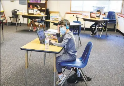  ?? EDUARDO CONTRERAS U-T ?? Steven Gortani, 6, and other children work on their laptops Tuesday at Chase Avenue Elementary School in El Cajon during the Cajon Valley Union School District’s emergency child care program.