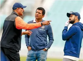  ?? — AP ?? Ravi Shastri is engaged in an animated conversati­on with BCCI selector Devang Gandhi ( centre) and Virat Kohli at a training session at the Oval on Wednesday.