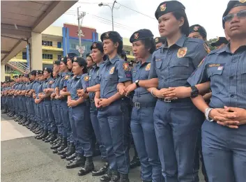  ??  ?? Female Police officers link arms as frontliner­s along IBP Road to prevent protesters from coming close to Batasan complex.