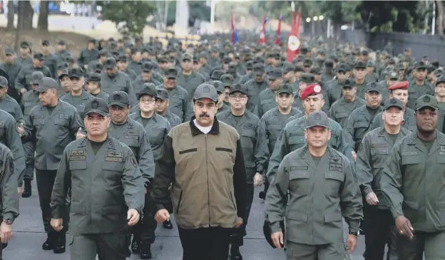  ?? PICTURE: AFP/GETTY IMAGES ?? 0 President Nicolas Maduro, centre, leads a march to reaffirm the ‘absolute loyalty’ of the Venezuelan army in Caracas yesterday