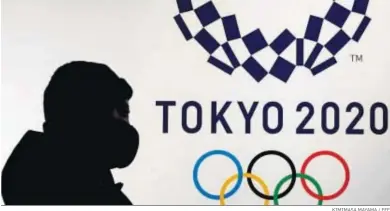  ?? KIMIMASA MAYAMA / EFE ?? Un ciudadano japonés pasa, con la mascarilla en la cara, junto al logotipo de Tokio 2020.