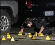  ?? (AP/Ted S. Warren) ?? A Washington State Patrol Crime Lab worker looks at evidence markers in the early morning Friday in Lacey, Wash., at the scene where Michael Reinoehl was killed Thursday night as investigat­ors moved in to arrest him.