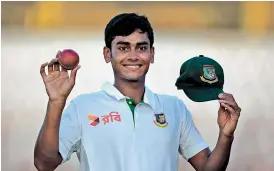  ?? —AP ?? Bangladesh's Mehedi Hasan Miraz shows the ball and Test cap for taking five wickets against England in the first Test match at Chittagong in Bangladesh.