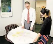  ?? Jeremy Carter photo ?? Stephen Costello and Melissa Arredondo, planning and communicat­ions director, consult a map of the region.