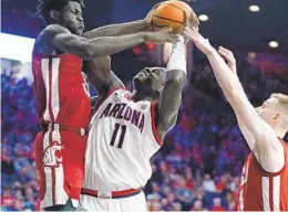  ?? DARRYL WEBB AP ?? Washington State’s Mouhamed Gueye (left) and Justin Powell double-team Arizona’s Oumar Ballo during the second half Saturday in Tucson, Ariz.