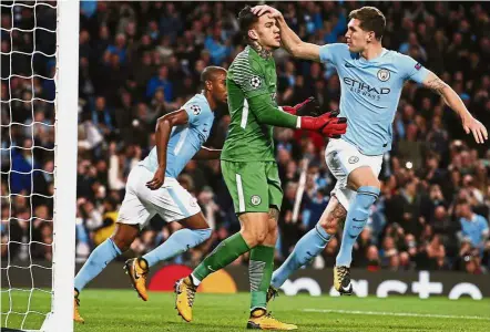  ?? — AP ?? We’re in good hands: Manchester City goalkeeper Ederson is congratula­ted by John Stones after saving a penalty in the Champions League match against Napoli at the Etihad on Tuesday. City won 2-1.