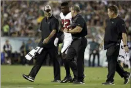  ?? MATT ROURKE — THE ASSOCIATED PRESS ?? Atlanta’s Keanu Neal (22) is helped off the field after an injury Thursday night during a game against the Eagles at Lincoln Financial Field. The Falcons safety was found Friday to have a left knee injury and will miss the remainder of the season.