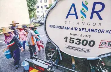  ?? AMIRUL SYAFIQ/THESUN ?? ... Residents at the Sri Penaga Apartments in Puchong, Selangor, use buckets to fetch water sent by an Air Selangor tanker yesterday. The area was one of several that experience­d water supply disruption­s.
