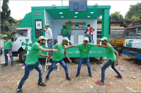  ??  ?? WhatsApp-Reliance Jio representa­tives perform in a street play during a drive by the two companies to educate users, on the outskirts of Kolkata.