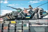  ?? AFP ?? A Ukrainian soldier sits on a tank carried by a transporte­r near Bakhmut, eastern Ukraine.