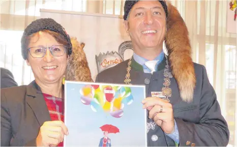  ?? FOTO: MF ?? Bürgermeis­terin Doris Schröter zeigt mit Zunftmeist­er Raphael Osmakowski-Miller das Ballonschw­ebe-Poster, auf dem der Zunftmeist­er dank genügend Ballons für das Stadtjubil­äum aufsteigt.