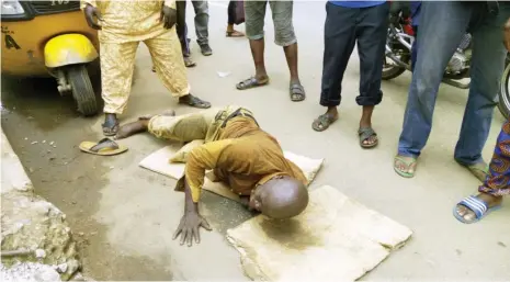  ?? Photo by: Opeyemi Kehinde ?? A tricycle rider, Michael Akande, lies on the ground after he was brutalised by a mobile policeman in Lagos yesterday.