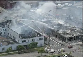  ?? BRIAN PETERSON - THE ASSOCIATED PRESS ?? Firefighte­rs work on an apartment building under constructi­on, Thursday, May 28, 2020, tentativel­y known as Midtown Corner, left, after it was burned to the ground in Minneapoli­s, Minn. during protests.