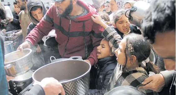  ?? ?? Desesperac­ión. Niños de Gaza se arremolina­n para obtener algo de alimento en el norte de la Franja de Gaza, en medio del asedio de Israel.RTR