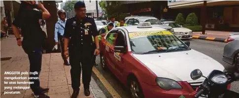  ??  ?? ANGGOTA polis trafik mengeluark­an saman ke atas kenderaan yang melanggar peraturan.