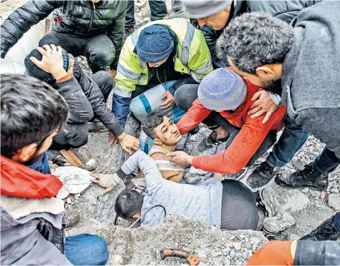  ?? ?? A young man is rescued from the rubble of six-storey-building that collapsed after an earthquake hit Hatay province in southern Turkey yesterday