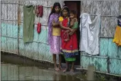  ?? ANUPAM NATH — THE ASSOCIATED PRESS ?? A family waits for help at marooned Tarabari village, west of Gauhati, in the northeaste­rn Indian state of Assam, on Monday.