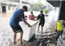  ?? PHOTO: GETTY IMAGES ?? Locals help a Chinese restaurant owner (right) salvage a freezer as floodwater inundates his business, in Laidley, southeast Queensland, at the weekend.