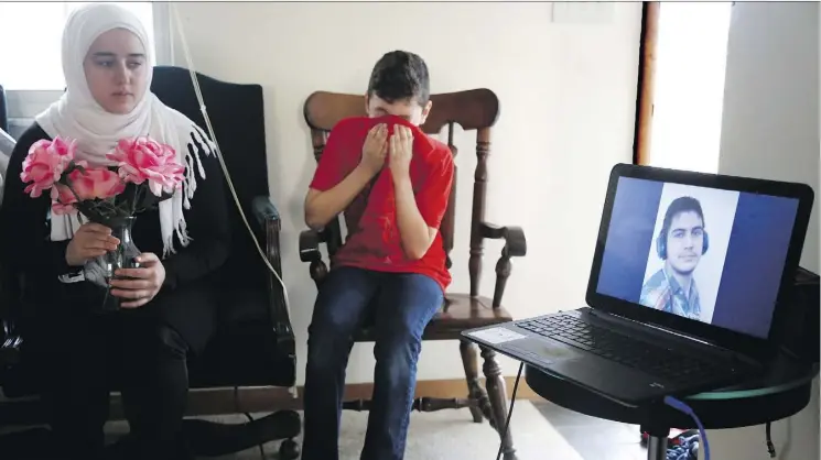  ?? PRESS PHOTOS: MARTHA IRVINE/THE ASSOCIATED ?? Syrian Amjud Moustafa Rifat wipes away tears in Columbus, Ohio, as he and sister Fatima listen to a song their brother, Hasib, wrote for the family.