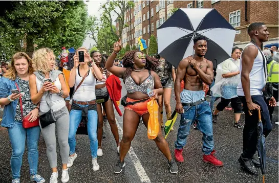  ?? PHOTOS: GETTY IMAGES ?? Revellers dance at the Notting Hill Carnival in London, England. While the carnival continue in full party mode, police made more than 100 arrests.