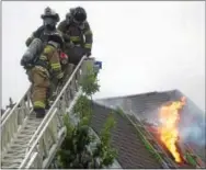  ?? PETE BANNAN – DIGITAL FIRST MEDIA ?? Longwood firefighte­rs leave the roof of a house in the 100 block of Osborne Circle in Pocopson after they opened a hole in the roof during a fire Monday. Nobody was injured in the blaze, which went to three alarms. The additional crews were required...