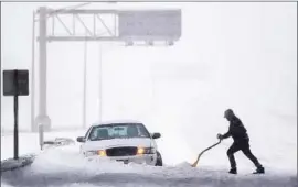  ?? Julio Cortez
Associated Press ?? A DRIVER TRIES to dig out a vehicle on the New Jersey Turnpike. Icy and snow-covered roadways stranded motorists from Kentucky to Pennsylvan­ia.