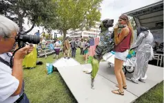  ??  ?? LEFT: Sully, a 115 pound Great Dane, jumps on his owner, Karina DeYoung, 18, after winning first place at the alien animal costume contest Saturday in Roswell during the city’s annual UFO Festival. ‘I love to dress up my animals,’ said DeYoung. ‘I...
