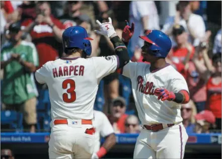  ?? MATT ROURKE — THE ASSOCIATED PRESS ?? The Philadelph­ia Phillies’ Bryce Harper celebrates with Jean Segura after hitting a home run during the sixth inning of a baseball game against the Colorado Rockies Sunday in Philadelph­ia. The Phillies won 7-5.