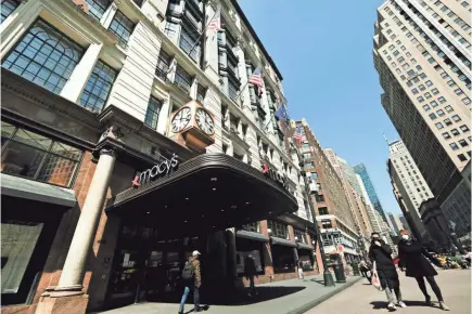  ??  ?? People walk past the temporaril­y closed Macy's flagship Herald Square store, Wednesday in New York.