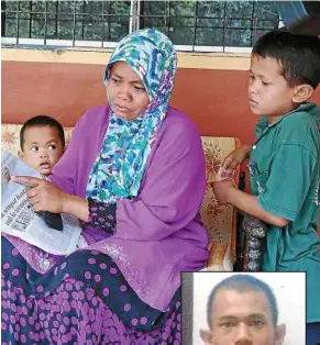  ??  ?? Looking for justice: Zuraida pointing at an article on Muhammad Suhaimi’s (inset) death, while her children look on.