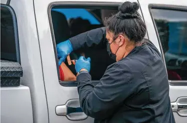  ?? Mark Mulligan / Staff photograph­er ?? Mayra Soriano administer­s a dose of the Johnson & Johnson COVID-19 vaccine during a vaccine drive hosted by FIEL on Saturday at the Spring Branch Community Healthcare Center in Houston.