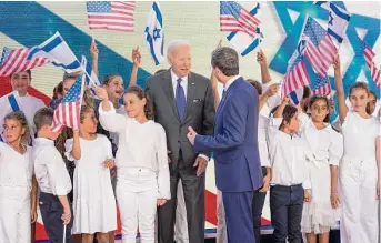  ?? Doug Mills/New York Times ?? Local schoolchil­dren wave flags as they welcome President Joe Biden to the residence of Israeli President Isaac Herzog on Thursday in Jerusalem.