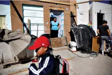  ?? Associated Press ?? ■ Ruth Aracely Monroy, center, looks out at her son Nahum Perla, left, as he plays in front of their home Jan. 28 on the outskirts of Tijuana, Mexico. The Perla family of El Salvador has slipped into a daily rhythm in Mexico while they wait for the U.S. to decide if they will win asylum. A modest home has replaced the tent they lived in at a migrant shelter.